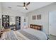 Bright bedroom featuring a ceiling fan, a bed with blue-and-grey lines, and dark-wooden storage units at 14727 Tudor Chase Dr, Tampa, FL 33626