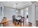Elegant dining room with tray ceilings, wood floors, stylish lighting, and contemporary decor at 14727 Tudor Chase Dr, Tampa, FL 33626