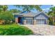 Charming blue home with a stone-accented facade, three-car garage, and a well-manicured lawn at 14727 Tudor Chase Dr, Tampa, FL 33626