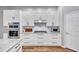 Bright kitchen features white cabinets, stainless steel appliances, granite countertops, and hardwood floors at 14727 Tudor Chase Dr, Tampa, FL 33626