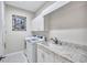 Laundry room featuring a washing machine, dryer, marble countertops, and ample storage space at 14727 Tudor Chase Dr, Tampa, FL 33626