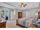 Bright main bedroom featuring tray ceilings, ceiling fan and private access to an outdoor patio at 14727 Tudor Chase Dr, Tampa, FL 33626