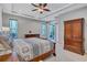 Bright main bedroom featuring tray ceilings, ceiling fan and carpet floors with views of the backyard at 14727 Tudor Chase Dr, Tampa, FL 33626