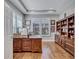 Home office featuring wood floors, tray ceilings, and a large wooden desk at 14727 Tudor Chase Dr, Tampa, FL 33626