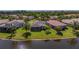 Aerial view of a home with solar panels, a screened lanai, and lake frontage at 16139 Coquina Bay Ln, Wimauma, FL 33598