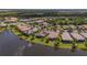 Overhead shot showcasing the home's lakefront location with solar panels and screened lanai at 16139 Coquina Bay Ln, Wimauma, FL 33598