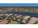 Wide aerial shot highlighting the home's location near a lake, mature trees, and manicured landscaping at 16139 Coquina Bay Ln, Wimauma, FL 33598