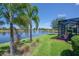 Beautiful backyard with a screened lanai overlooking a serene lake and landscaped greenery at 16139 Coquina Bay Ln, Wimauma, FL 33598