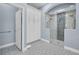 Well-lit bathroom featuring a spacious glass shower, storage cabinets, and designer tile flooring at 16139 Coquina Bay Ln, Wimauma, FL 33598