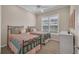 Comfortable bedroom features two twin beds with decorative comforters and a bright window at 16139 Coquina Bay Ln, Wimauma, FL 33598
