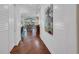 Inviting hallway with wood floors and board and batten walls, leading to an open living area and water view at 16139 Coquina Bay Ln, Wimauma, FL 33598