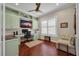 Cozy home office featuring custom built-ins, hardwood floors, and a comfortable seating area at 16139 Coquina Bay Ln, Wimauma, FL 33598