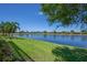 Scenic lake view surrounded by lush green lawn and well-maintained landscaping at 16139 Coquina Bay Ln, Wimauma, FL 33598
