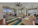 Bright living room featuring waterfront view, two sofas, ceiling fan, and colorful striped rug at 16139 Coquina Bay Ln, Wimauma, FL 33598