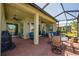 Outdoor patio with brick flooring, ceiling fans, and comfortable seating under a screened enclosure at 16139 Coquina Bay Ln, Wimauma, FL 33598