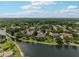 Scenic aerial view of a residential community nestled among lush trees and bordering a tranquil lake at 16910 Equestrian Trl, Odessa, FL 33556