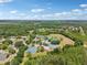 An aerial view of community sports facilities, including tennis and basketball courts, surrounded by lush greenery and neighborhood homes at 16910 Equestrian Trl, Odessa, FL 33556