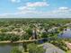 Scenic aerial view of a residential community nestled among lush trees and bordering a tranquil lake at 16910 Equestrian Trl, Odessa, FL 33556