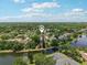 Scenic aerial view of a residential community nestled among lush trees and bordering a tranquil lake at 16910 Equestrian Trl, Odessa, FL 33556