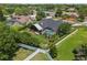 Aerial view of a home's backyard featuring a screened-in pool, lush landscaping, and a white fence at 16910 Equestrian Trl, Odessa, FL 33556
