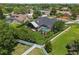 Aerial view of a home's backyard featuring a screened-in pool, lush landscaping, and a white fence at 16910 Equestrian Trl, Odessa, FL 33556