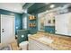 This bathroom is teal with a large mirror and granite countertop at 16910 Equestrian Trl, Odessa, FL 33556