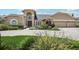 Inviting two-story tan home featuring an arched entryway, a three-car garage, and beautifully landscaped grounds at 16910 Equestrian Trl, Odessa, FL 33556