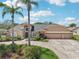 Beautiful home features a well-manicured lawn, mature landscaping, and a spacious three-car garage, exuding charm and functionality at 16910 Equestrian Trl, Odessa, FL 33556