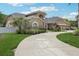 Elegant single-Gathering home boasts a winding driveway, manicured lawn, and lush landscaping at 16910 Equestrian Trl, Odessa, FL 33556