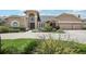 Inviting two-story tan home featuring an arched entryway, a three-car garage, and beautifully landscaped grounds at 16910 Equestrian Trl, Odessa, FL 33556