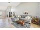 Spacious living room featuring travertine flooring, vaulted ceilings, and a comfortable gray sectional sofa at 16910 Equestrian Trl, Odessa, FL 33556