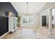 Spacious living room featuring stone floors, plantation shutters, and a decorative chandelier at 16910 Equestrian Trl, Odessa, FL 33556