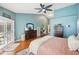 Spacious main bedroom with hardwood floors, cool blue accent wall, and a ceiling fan at 16910 Equestrian Trl, Odessa, FL 33556