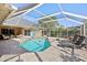 Screened-in pool with sun loungers, greenery, and a relaxing spa, perfect for outdoor enjoyment at 16910 Equestrian Trl, Odessa, FL 33556