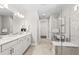 Modern bathroom with double vanity, soaking tub, glass-enclosed shower, and neutral color palette at 17206 Luminous Ave, Venice, FL 34293