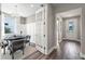 Formal dining room with elegant chandelier, and wall paneling, accessed via a glass-paned door from the foyer at 17206 Luminous Ave, Venice, FL 34293