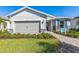 Charming one-story home featuring a two-car garage and beautifully landscaped front yard on a sunny day at 17206 Luminous Ave, Venice, FL 34293