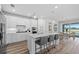 Contemporary kitchen with a large island, stainless steel appliances, and a view to the outdoor pool at 17206 Luminous Ave, Venice, FL 34293