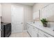 Functional laundry room with a washer and dryer, ample counter space, and white cabinetry at 17206 Luminous Ave, Venice, FL 34293