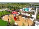 A playground and picnic area surrounded by palm trees and landscaping, community pool in background at 17206 Luminous Ave, Venice, FL 34293