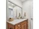 Bathroom featuring warm wood cabinets, granite countertops, and a decorative vanity mirror at 1735 Maryland Ne Ave, St Petersburg, FL 33703