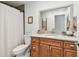 Bathroom featuring warm wood cabinets, granite countertops, toilet, and a decorative vanity mirror at 1735 Maryland Ne Ave, St Petersburg, FL 33703