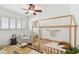 Bedroom with wooden framed bed, shutters on the windows, and a plush armchair at 1735 Maryland Ne Ave, St Petersburg, FL 33703