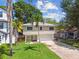 Charming two-story home featuring a well-manicured lawn, a two-car garage, and lush tropical landscaping at 1735 Maryland Ne Ave, St Petersburg, FL 33703