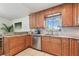 Kitchen features granite countertops, stainless dishwasher, sink, and beautiful wood cabinets at 1735 Maryland Ne Ave, St Petersburg, FL 33703