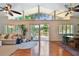 Spacious living room featuring hardwood floors, a vaulted ceiling, and a sliding glass door to the deck at 1735 Maryland Ne Ave, St Petersburg, FL 33703