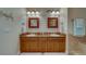 Double sink bathroom with granite counters and wooden cabinets at 17735 Gulf Blvd # 202, Redington Shores, FL 33708