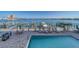 Community pool with bay view and boat docks features lounge chairs and tables at 17735 Gulf Blvd # 202, Redington Shores, FL 33708