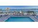 Community pool with bay view and boat docks features lounge chairs and tables at 17735 Gulf Blvd # 202, Redington Shores, FL 33708