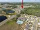 Aerial view of a community with a pool, basketball court, neighborhood, and nearby lakes at 1823 Moon Cactus Ct, Ruskin, FL 33570